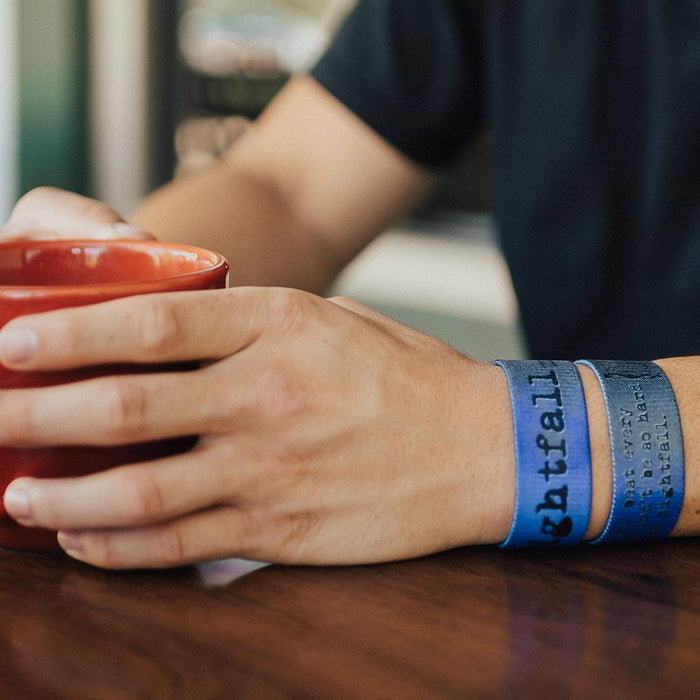 Lifestyle image of arm resting on a table with 2 Nightfall on wrist