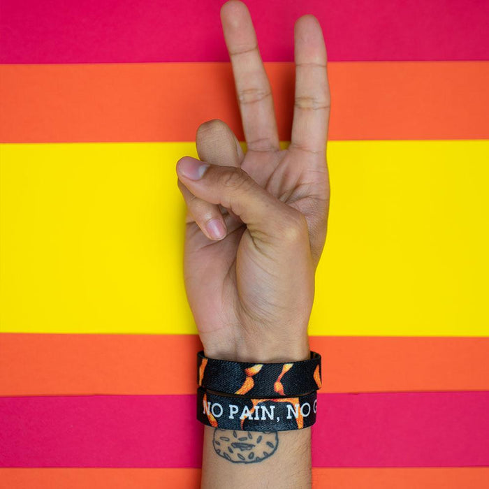 Studio photo of a hand signing a peace sign in front a bright colored background showing the inside and outside design of the no pain, no gain single