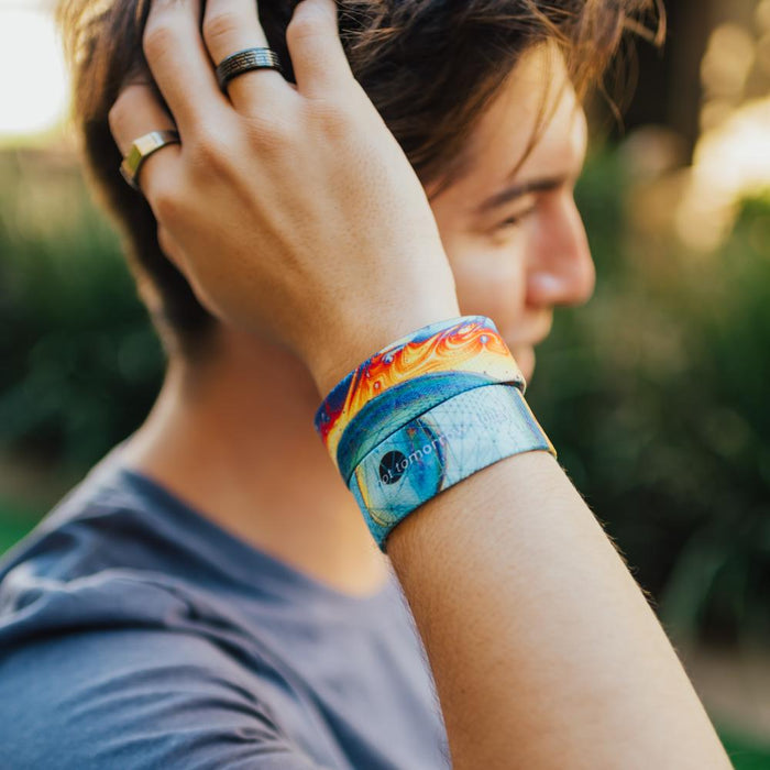 lifestyle image of a man wearing two Not Tomorrow, Today. One showing the front and one showing the back while holding his hair