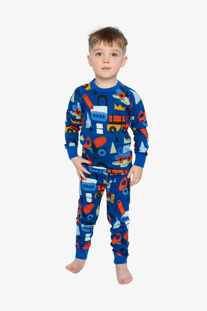 Child wearing the Deux par Deux blue truck print organic cotton pajama set, lookbook photo 1