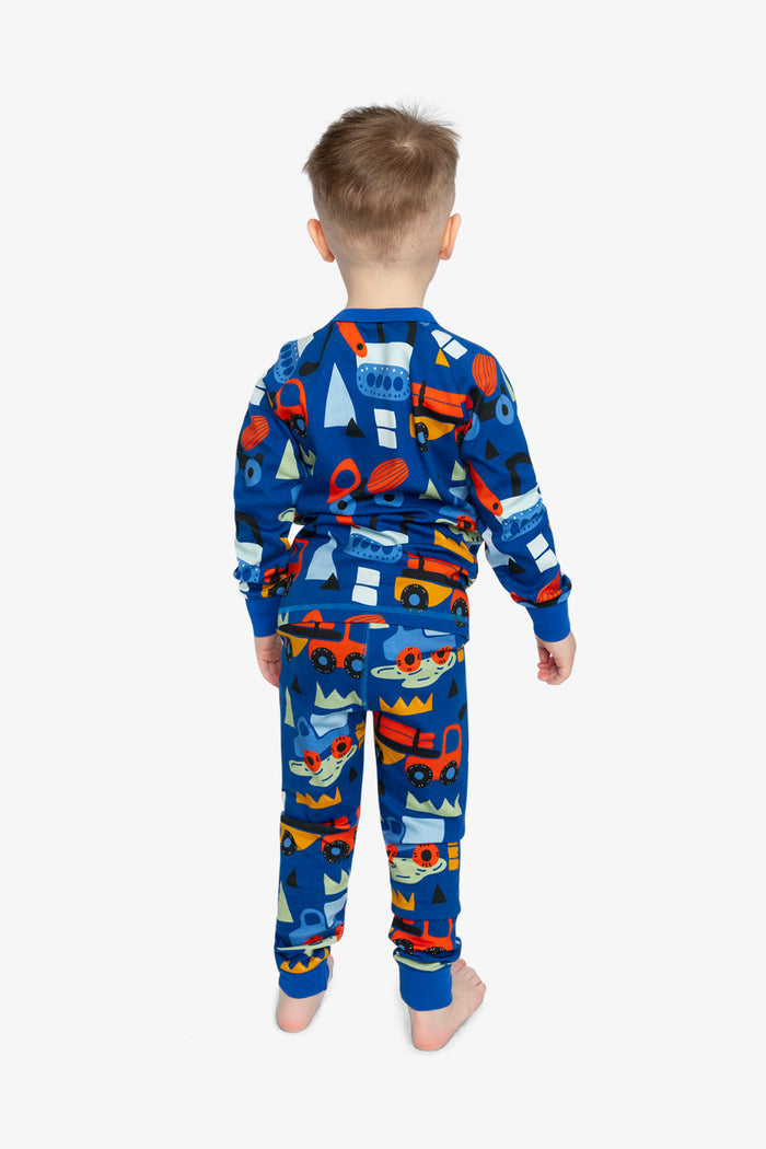 Child wearing the Deux par Deux blue truck print organic cotton pajama set, lookbook photo 2