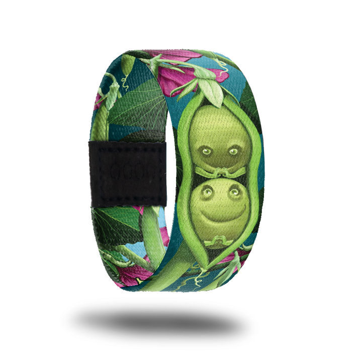 Outside design for Peas In A Pod. Dark teal background with a few pink flowers and green plant life. Centered is an illustrated drawing of a green pea pod with two green peas inside with drawn smiles and hands