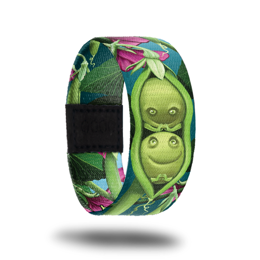 Outside design for Peas In A Pod. Dark teal background with a few pink flowers and green plant life. Centered is an illustrated drawing of a green pea pod with two green peas inside with drawn smiles and hands