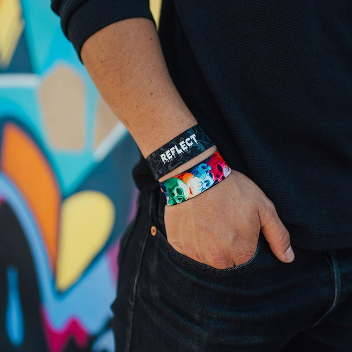 Young adult male wearing two reflect ZOX with hand in his pocket. One ZOX shows the inside while the other shows the outside