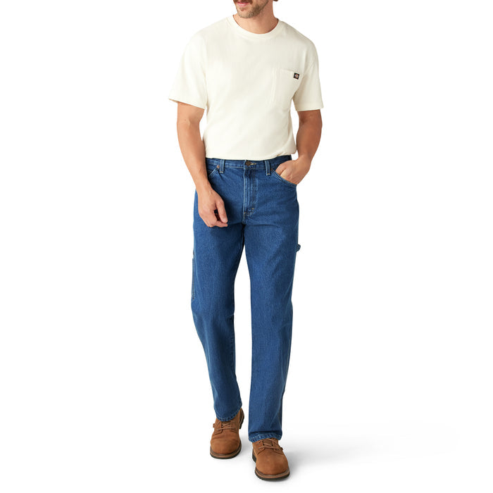Man wearing cream short-sleeve t-shirt and blue denim carpenter jeans with brown work boots.