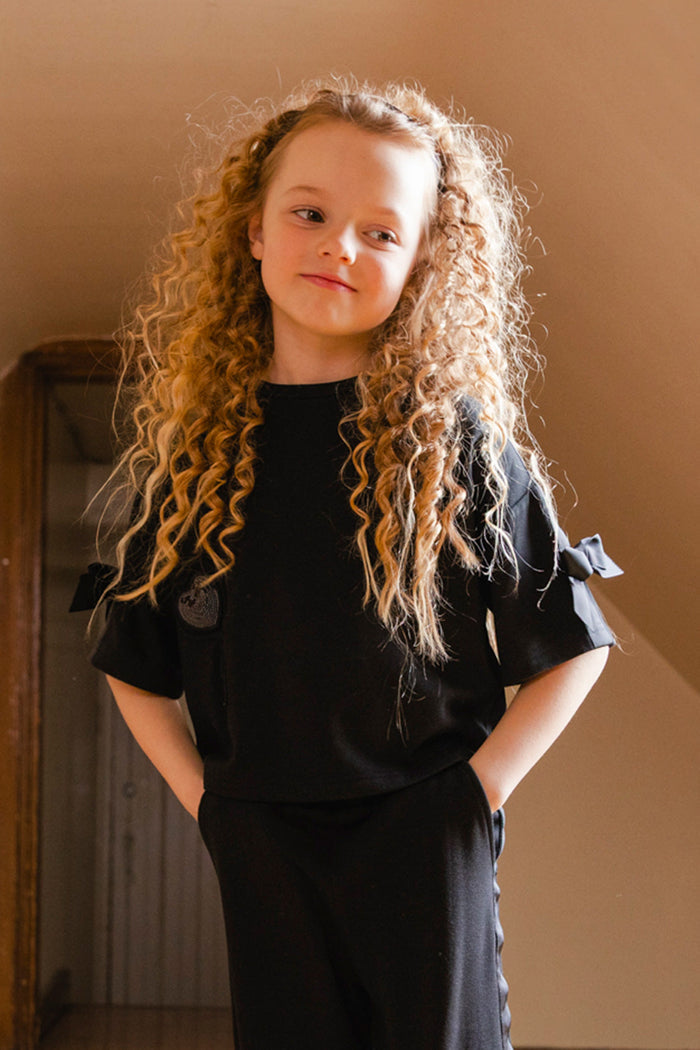 Child in the black milano top with heart balloon by Deux par Deux