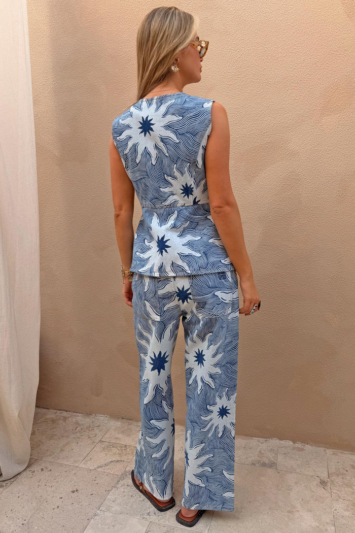 Soleil Jeans in blue denim with oversized sun motifs, styled with the matching waistcoat as a co-ord set.