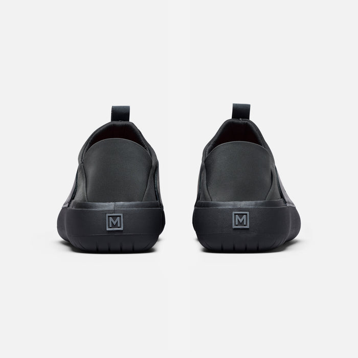 The Relaxed 2 gallery position 1 rear view showing black slip-on chef shoes with MISE logo on heel tab.