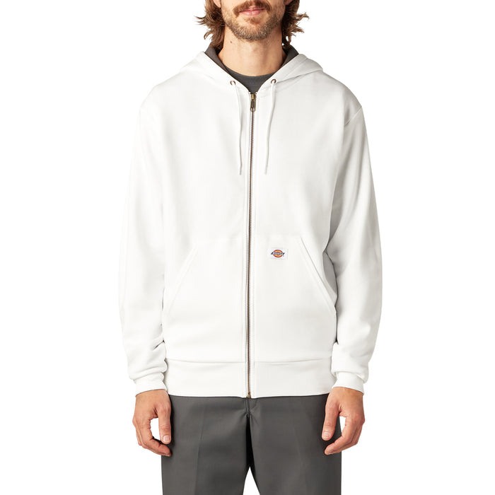 Man wearing cream-colored fleece zip hoodie with dark gray lining at neckline and charcoal pants.