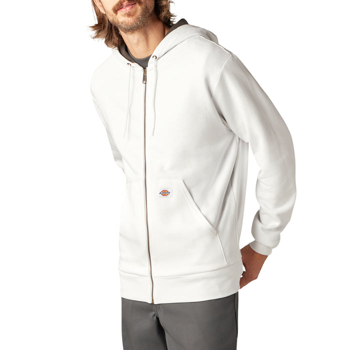 Man wearing cream-colored zip-up fleece hoodie with kangaroo pocket and dark gray pants.