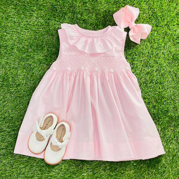 A pink smocked dress with ruffles