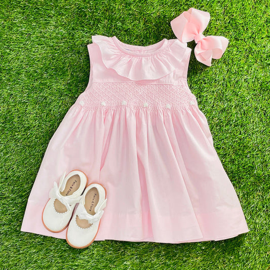 A pink smocked dress with ruffles