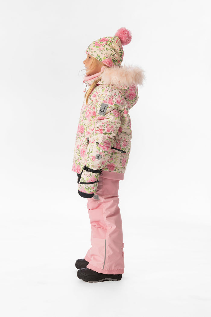 Side view of a child wearing the pink mini flower PLAY jacket and pink snow pants