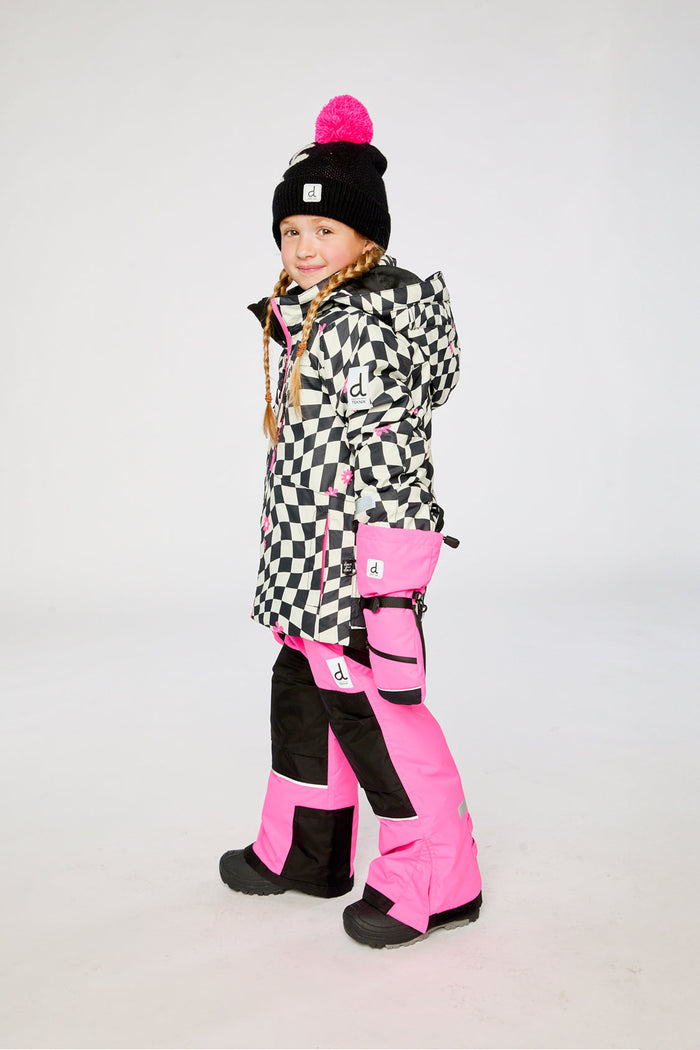 Child in the checkered and bright pink TEKNIK snowsuit, three-quarter view