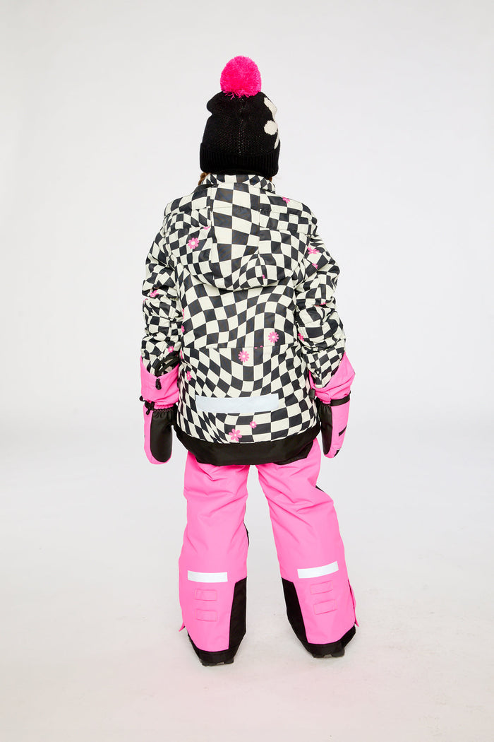 Child in the checkered and bright pink TEKNIK snowsuit, back view
