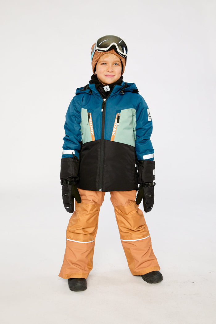 Child wearing the navy and tan TEKNIK snowsuit with goggles, front view