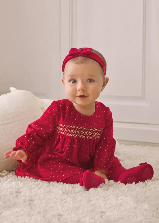Baby girl wearing red Mayoral velvet dot dress with long sleeves