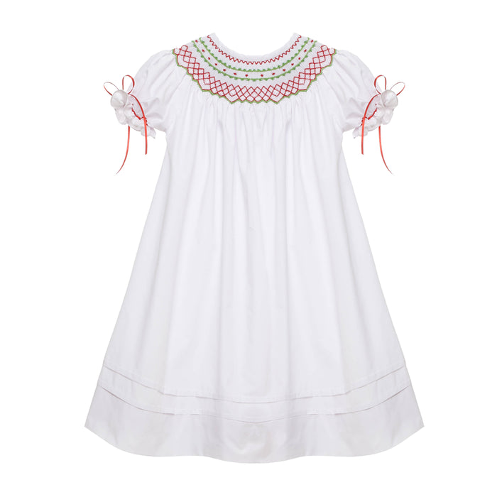 A white classic smocked Christmas bishop dress with red and green ribbons and trim.