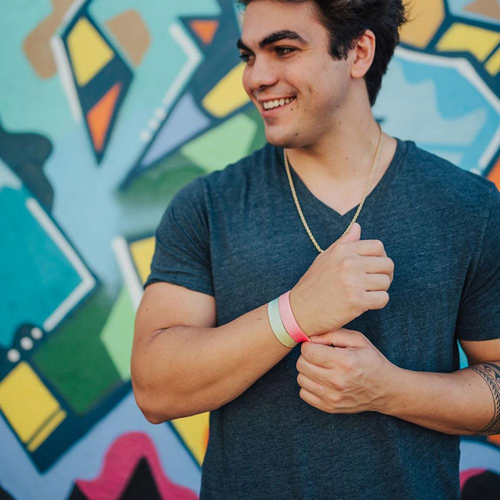 Lifestyle image of someone smiling with You Are Perfect For Something on their wrist and one other Zox wristband
